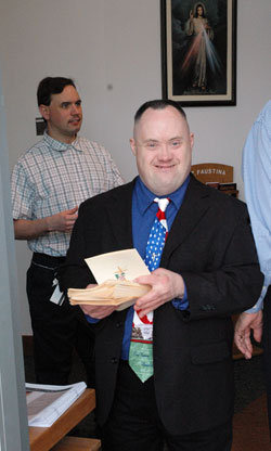 St. Mark the Evangelist parishioner and SPRED participant Mike Risch of Indianapolis welcomes people to St. Mark Church on April 27 for the archdiocesan SPRED Mass. St. Mark parishioner and SPRED participant John McGee, left, also hands out liturgy guides. (Photo by Mary Ann Wyand)