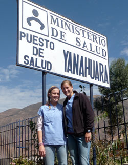 As sisters who played together on numerous sports teams through the years, Megan, left, and Kelly Gardner teamed up again this summer to offer hope and health care at medical clinics in Peru. Here, they pose near a sign for one of the clinics. (Submitted photo)