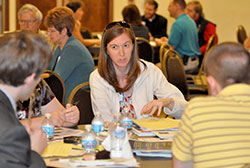 Julie Johnstone of St. Mary Parish in Indianapolis discusses evangelization ideas with people at her table during a parish evangelization team building workshop offered by the archdiocesan Office of Catholic Education (OCE) at Our Lady of the Greenwood Parish in Greenwood on May 30. (Photo by Natalie Hoefer)