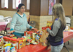 Jennifer Bailey, a member of Annunciation Parish in Brazil, helps a client of the parish’s food pantry on Feb. 3. The pantry, which is operated by a conference of the Society of St. Vincent de Paul based in the parish, serves more than 200 households per month. (Photo by Sean Gallagher)