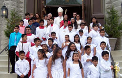 Archbishop Joseph W. Tobin and Franciscan Father Thomas Merrill pose on May 17 on the steps of St. Mary Church in New Albany with youths who recently received the sacraments of first Communion and confirmation at the New Albany Deanery faith community. (Photo by Leslie Lynch)	