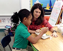 Teacher Amy Plant listens as Amyah Lewis shares her observations about her project on plant seedlings. (Submitted photo)