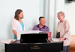 Franciscan Sister Christine Ernstes, right, shares a smile with Anna Johannigman and Anna’s father, Joe Johannigman, before Mass on June 12 at Immaculate Conception Church in Millhousen in the Batesville Deanery. Anna sings during Mass while Joe plays the piano. (Submitted photo by Amy Hermesch)