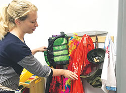 Jessica McDonald displays some of the costumes that are used for children’s “play therapy” at Catholic Charities in Bloomington on May 31. (Photo by Katie Rutter)