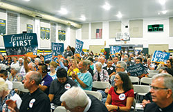 Those gathered for a rally promoting a “families first” 2018 federal budget hold signs during an IndyCAN gathering in the gymnasium of Holy Spirit Catholic School in Indianapolis on Aug. 30. (Photo by Natalie Hoefer)