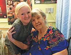 Nathalie Plum, left, a senior at Indiana University and a member of St. Paul Catholic Center, both in Bloomington, embraces Melia Davis, a resident of Golden LivingCenter in Bloomington, on Nov. 16. Plum is a volunteer with Never Alone: Ministry to the Elderly, a program of the campus ministry of St. Paul Catholic Center. (Photo by Natalie Hoefer)