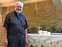 Father Clement Davis stands on Sept. 4 in St. Bartholomew Church in Columbus. Ordained a priest as a Benedictine monk in 1970, he has been an archdiocesan priest since 1983. (Photo by Sean Gallagher) 