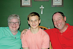 After a harrowing journey from Ukraine to the United States, Anton Bezborodov is in his true home in Indianapolis with Beth and Thomas Wright, members of St. John the Evangelist Parish in Indianapolis. (Photo by John Shaughnessy)