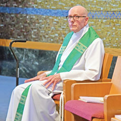 Retired Father Stephen Jarrell listens to a reading proclaimed while concelebrating a July 11 Mass in the chapel of Envive Healthcare of Beech Grove where he lives. (Photo by Sean Gallagher)